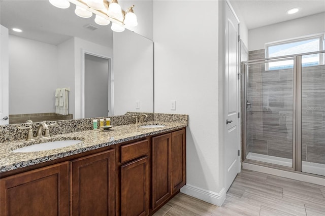 bathroom featuring a shower with shower door, wood-type flooring, and vanity