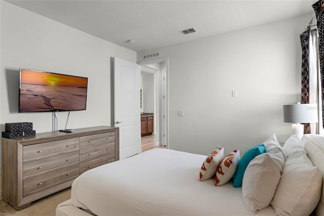 bedroom with a textured ceiling and light colored carpet