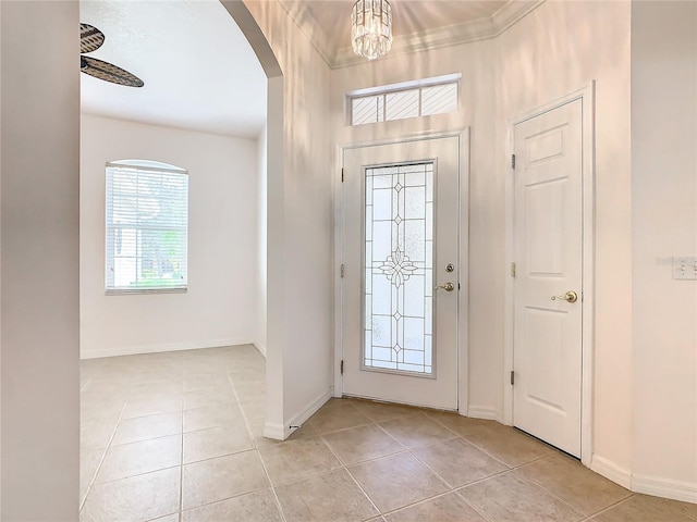 foyer entrance with crown molding and light tile patterned floors