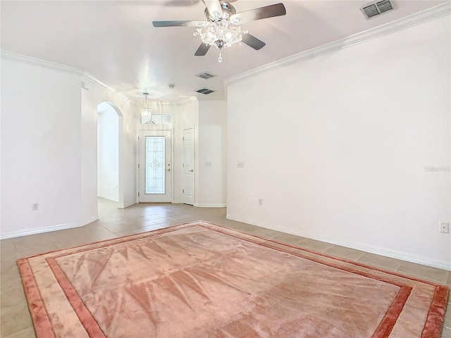 tiled spare room featuring ceiling fan and ornamental molding