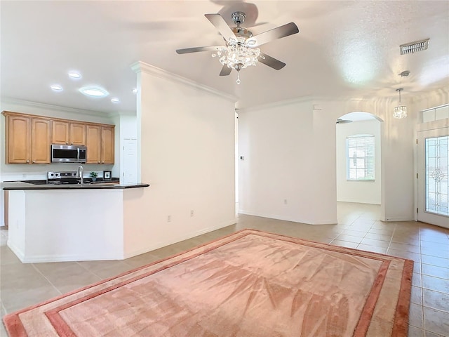 kitchen featuring light tile patterned flooring, stainless steel appliances, crown molding, ceiling fan, and decorative light fixtures