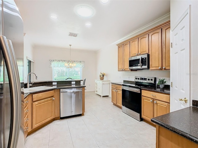 kitchen with appliances with stainless steel finishes, sink, a chandelier, and a wealth of natural light