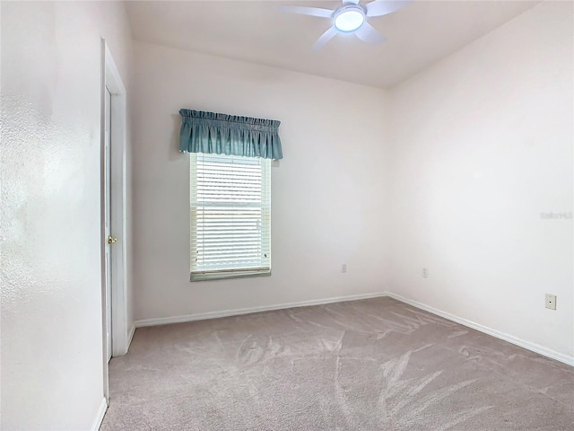 empty room featuring ceiling fan and light colored carpet