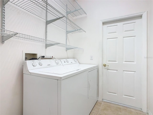 laundry area with light tile patterned floors and washing machine and clothes dryer