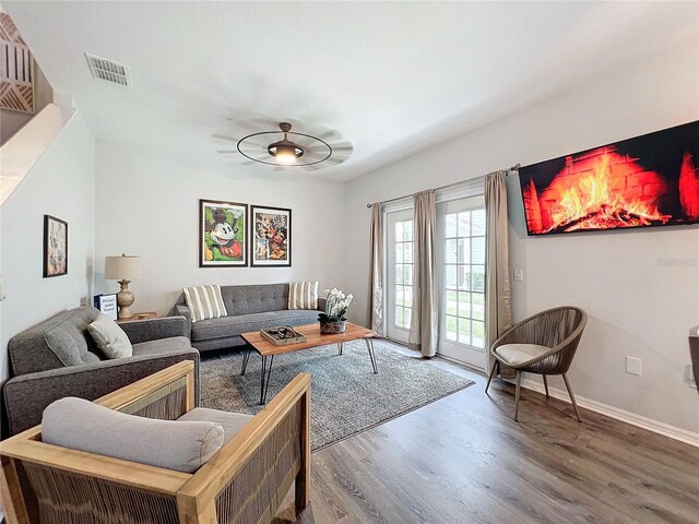 living room featuring wood-type flooring and ceiling fan