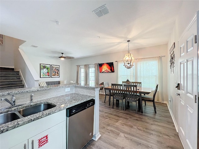 kitchen with ceiling fan with notable chandelier, white cabinetry, decorative light fixtures, stainless steel dishwasher, and light hardwood / wood-style floors