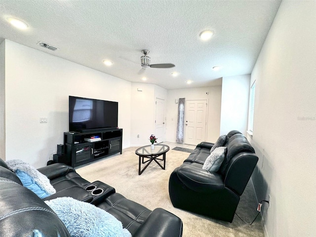 carpeted living room featuring a textured ceiling and ceiling fan