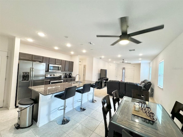 dining room with ceiling fan, sink, and light tile patterned floors