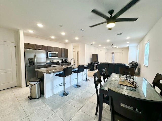 dining room with ceiling fan, light tile patterned floors, and sink