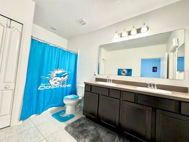 bathroom featuring tile patterned floors, toilet, a textured ceiling, and vanity