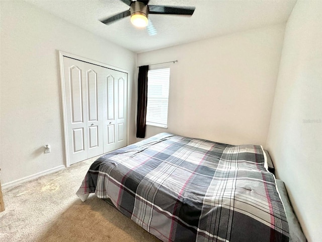 carpeted bedroom with ceiling fan and a closet