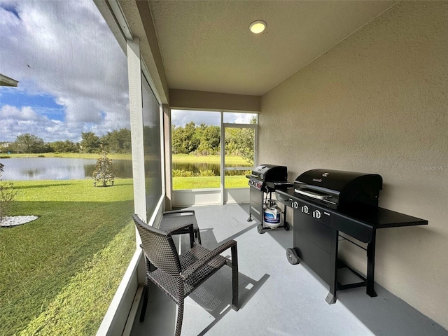 sunroom featuring a water view