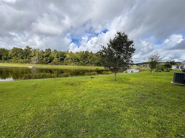 view of yard with a water view and central AC