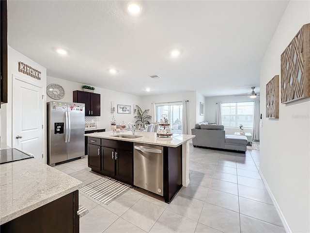 kitchen featuring sink, an island with sink, light tile patterned flooring, ceiling fan, and stainless steel appliances