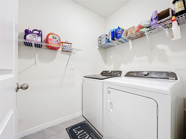 clothes washing area with light tile patterned flooring and washing machine and clothes dryer