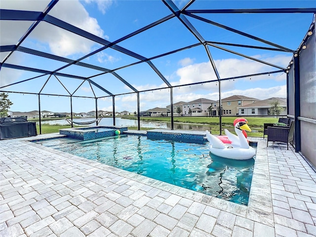 view of pool with a patio area, a lanai, an in ground hot tub, and a water view