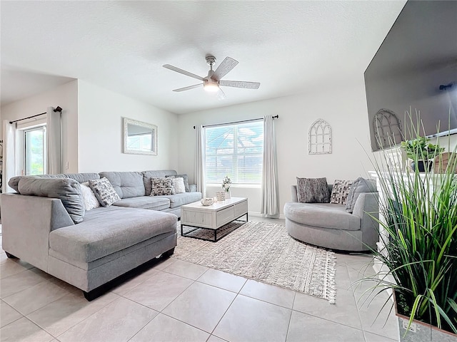 living room featuring a textured ceiling, light tile patterned floors, plenty of natural light, and ceiling fan