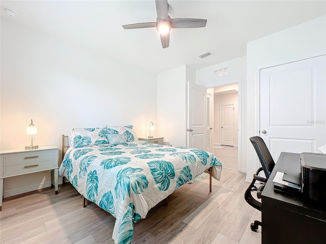 bedroom with ceiling fan, visible vents, baseboards, and light wood-style floors
