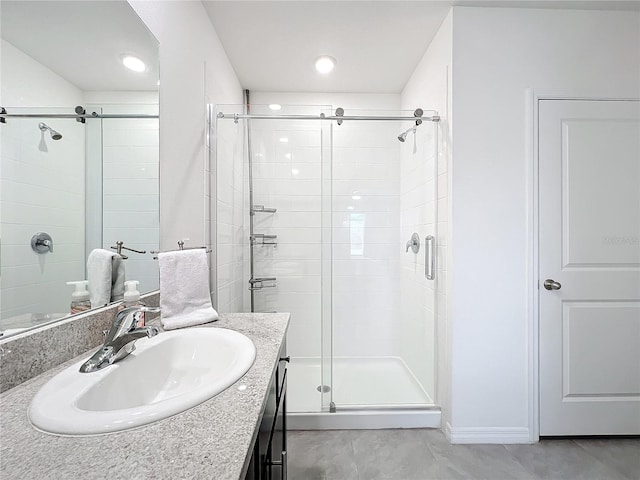 bathroom featuring vanity and a shower with shower door