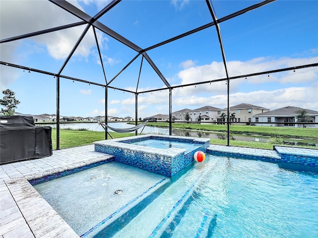 view of pool with glass enclosure, a water view, area for grilling, an in ground hot tub, and a lawn