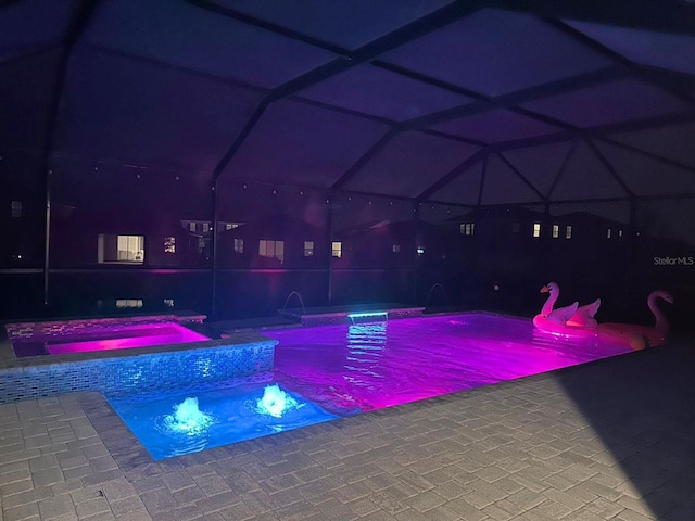 view of swimming pool with a patio, pool water feature, and an in ground hot tub