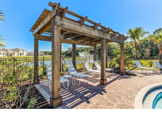 deck with a patio, a pergola, and a water view