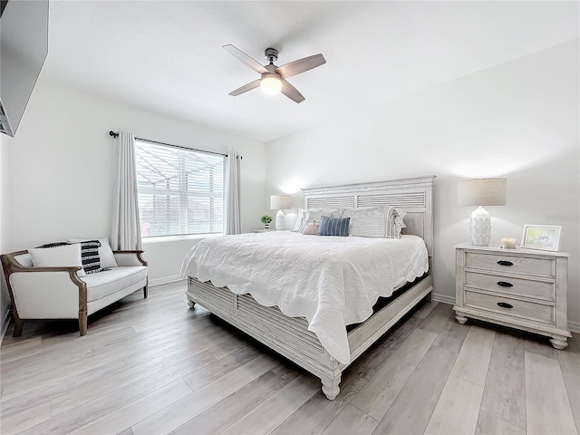 bedroom with a ceiling fan, baseboards, and light wood-style flooring