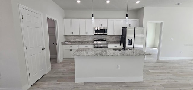 kitchen featuring stainless steel appliances, light hardwood / wood-style floors, a kitchen island with sink, and white cabinetry