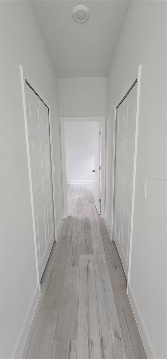 corridor with light hardwood / wood-style floors