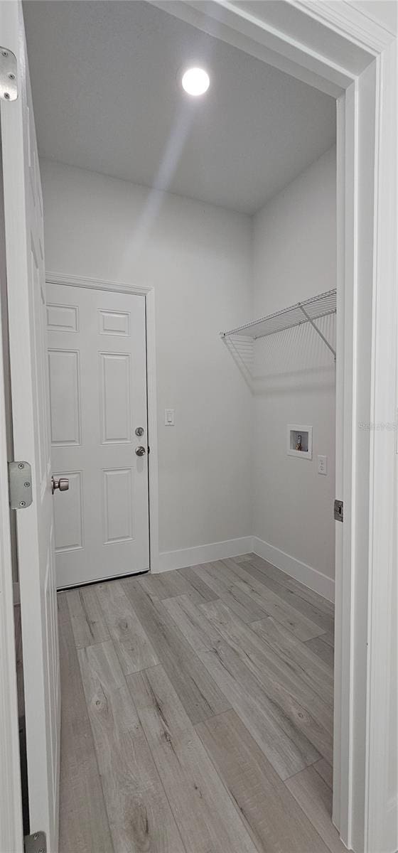 laundry area with washer hookup and light hardwood / wood-style floors