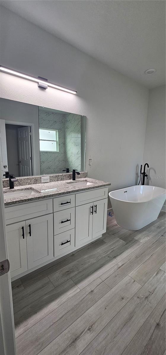 bathroom featuring vanity, hardwood / wood-style flooring, and plus walk in shower