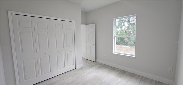 unfurnished bedroom featuring a closet and light hardwood / wood-style floors