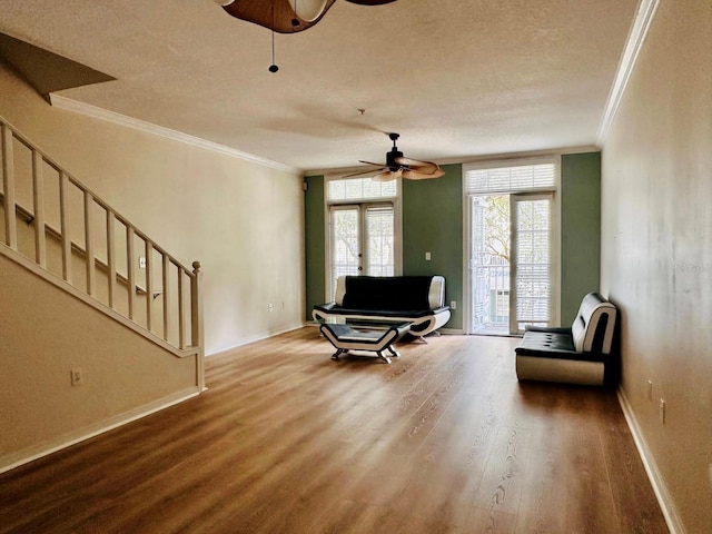 living area with crown molding, hardwood / wood-style floors, and ceiling fan