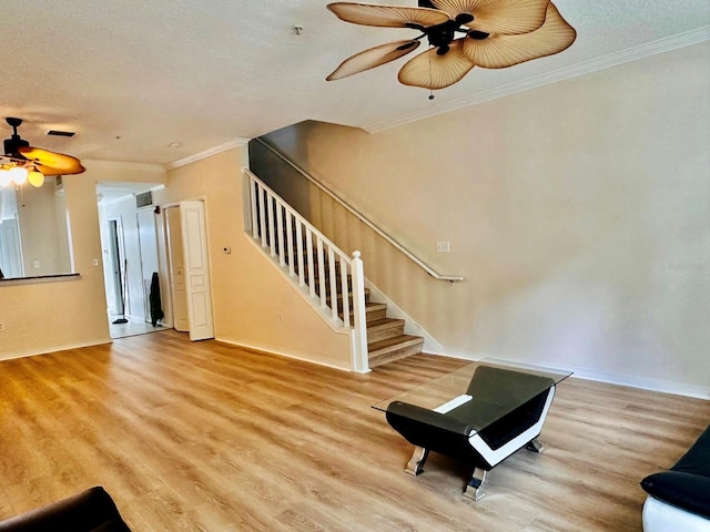 interior space featuring ceiling fan, a textured ceiling, crown molding, and light hardwood / wood-style flooring