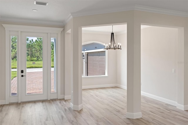 entryway featuring an inviting chandelier, crown molding, and light hardwood / wood-style floors