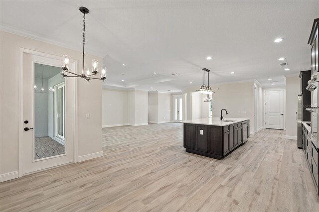 kitchen featuring light hardwood / wood-style flooring, a notable chandelier, hanging light fixtures, and sink