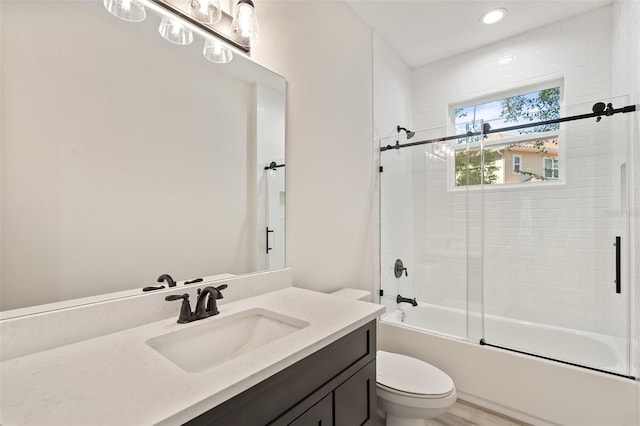 full bathroom featuring shower / bath combination with glass door, vanity, hardwood / wood-style floors, and toilet