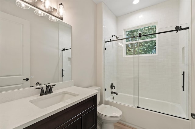 full bathroom featuring shower / bath combination with glass door, vanity, and toilet