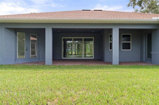 back of house with a lawn and a patio