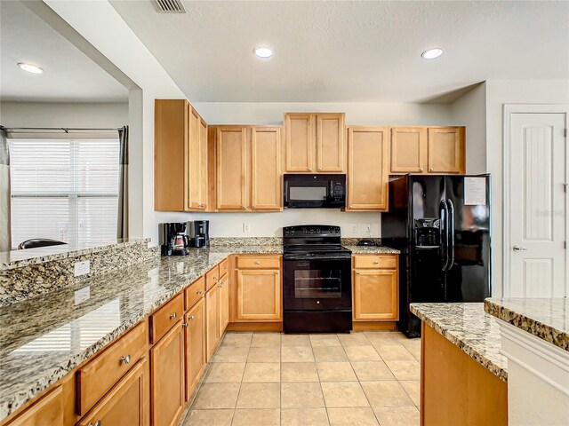 kitchen featuring black appliances, a textured ceiling, light tile patterned flooring, and light stone countertops