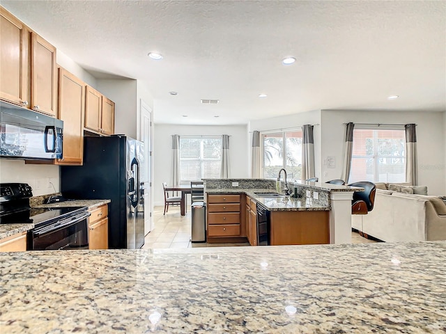 kitchen featuring a textured ceiling, black appliances, sink, light stone countertops, and light tile patterned flooring