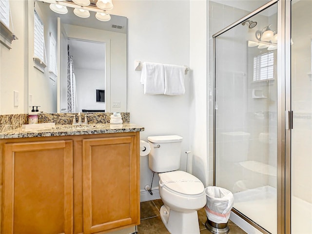 bathroom with tile patterned floors, toilet, a shower with door, and vanity