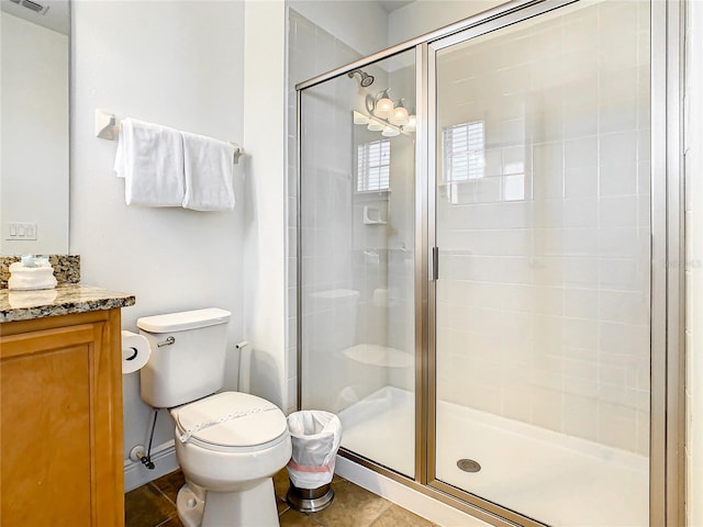 bathroom featuring tile patterned floors, a shower with shower door, toilet, and vanity