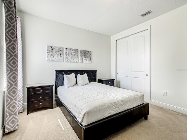 bedroom featuring light colored carpet and a closet