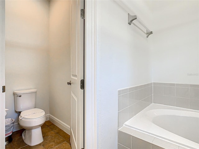 bathroom featuring toilet and tiled tub