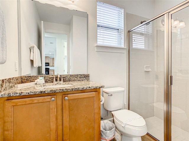 bathroom featuring vanity, toilet, and walk in shower