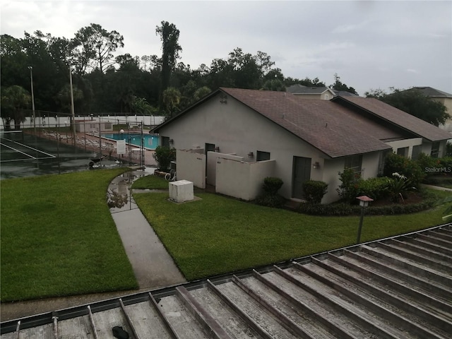 view of side of home featuring a fenced in pool and a yard