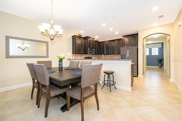 dining space with a chandelier and light tile patterned floors