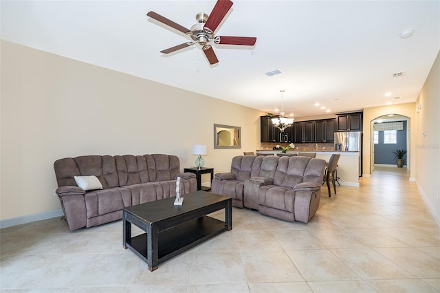 tiled living room featuring ceiling fan with notable chandelier