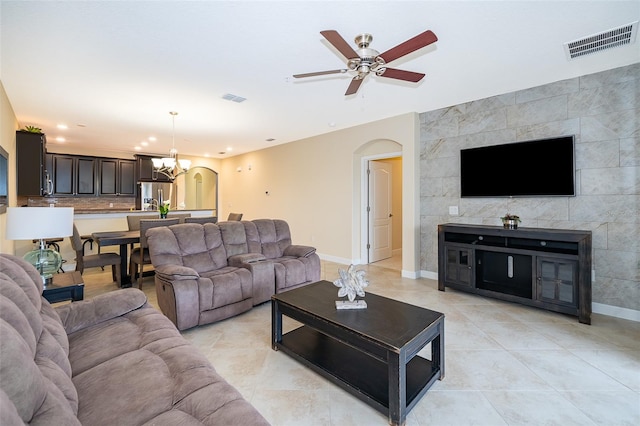 living room with ceiling fan with notable chandelier and light tile patterned floors